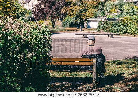 Senior Man Is Sitting On A Bench