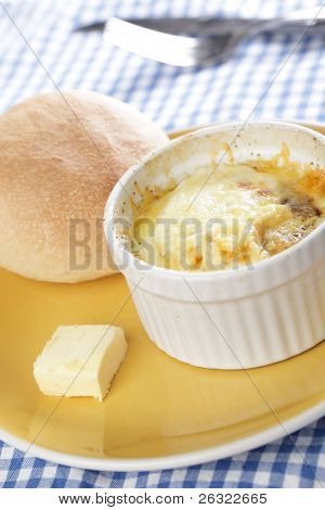 Breakfast with Swiss styled baked eggs in ramekin with the bun