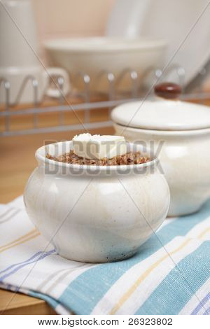 Hrnec s horké kaše, kaše, kostka másla