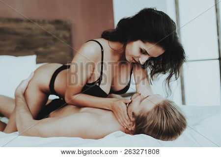 Girl Looks Into Eyes Man. Person In Black Underwear. White Linens. Woman With Sexy Man Topless. Girl