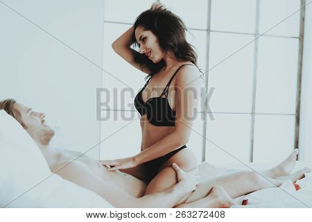 Girl Sitting On Man. Person In Black Underwear. White Linen. Male On Bed. Woman With Man Topless. Gi
