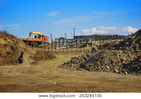 Details of construction site with truck and concrete slabs. Heaps of soil. Blue sky. Clay. Kazakhstan (Ust-Kamenogorsk)