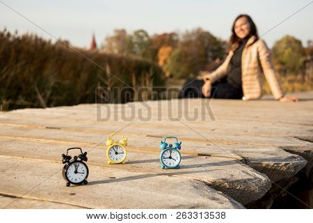 Three Small Alarm Retro Clocks On Wooden Surface. Autumn Abstract Photo.