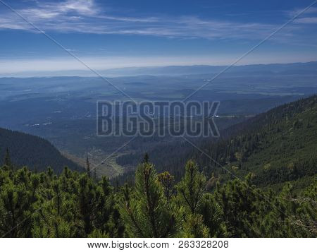 View From Tatra Mountains Trail On Valley With Tatranska Lomnice And Blue Misty Slopes Of Hills In T