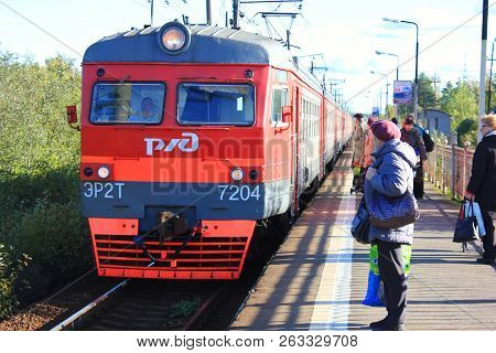 St. Petersburg, Russia - September 29, 2018: Local Train Arriving At Platform With Waiting Passenger