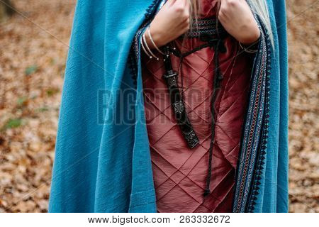 A Girl With Long Hair, Blonde, In A Blue Cape And A Pink Dress, Walks Through The Autumn Forest, Alo