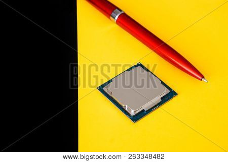 A Computer Processor For The Lga 1151 Socket And A Pen On A Yellow Background. Computer Techologies.