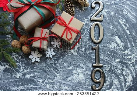 Festive Christmas Composition With Gifts, Boxes, Cones, Walnuts, Red Poinsettia Flowers On A Wooden 