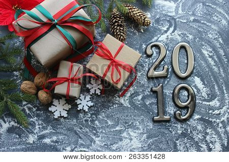 Festive Christmas Composition With Gifts, Boxes, Cones, Walnuts, Red Poinsettia Flowers On A Wooden 