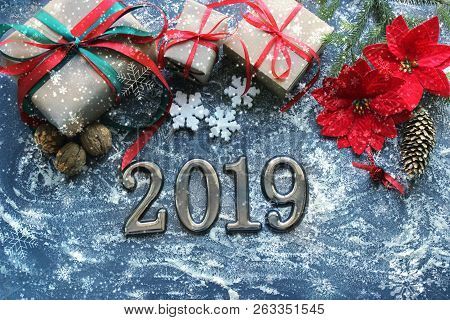 Festive Christmas Composition With Gifts, Boxes, Cones, Walnuts, Red Poinsettia Flowers On A Wooden 