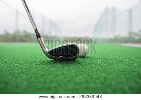 Golf Club And Ball On A Synthetic Grass Mat At A Practice Range.