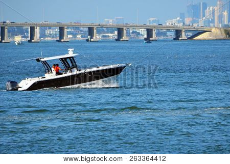 Outboard Powered Motorboat Cruising The Florida Intra-coastal Near Miami Beach With A Causeway Bridg