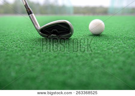 Golf Club And Ball On A Synthetic Grass Mat At A Practice Range.