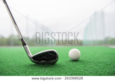 Golf Club And Ball On A Synthetic Grass Mat At A Practice Range.