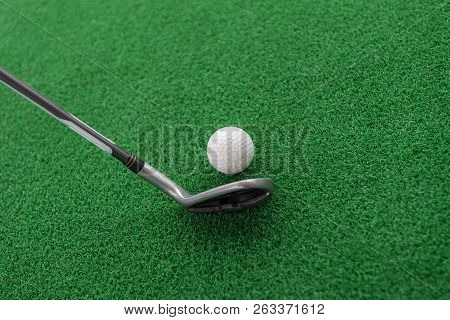 Golf Club And Ball On A Synthetic Grass Mat At A Practice Range.