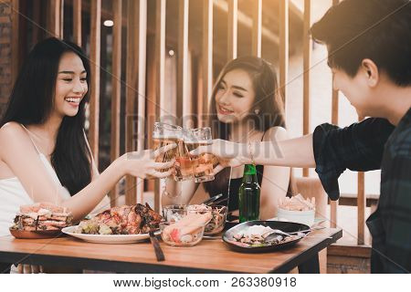 Teenager Having Enjoy Drinking Beer And Clinking Glass In Dinner Restaurant.
