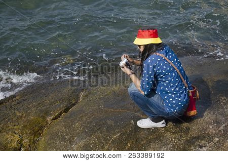 Thai Woman People Posing For Take Photo On The Rock In The Sea In Chonburi, Thailand