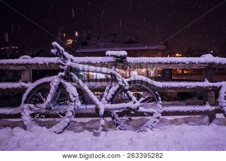 end of biking season.parked bicycle covered by snow from a heavy snowstorm.Winter cycling
