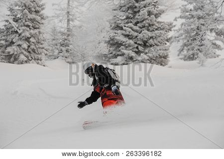 Man Riding Down On The Snowboard On The Powdered Snow In The Mountain Tourist Resort In Goderzi, Geo