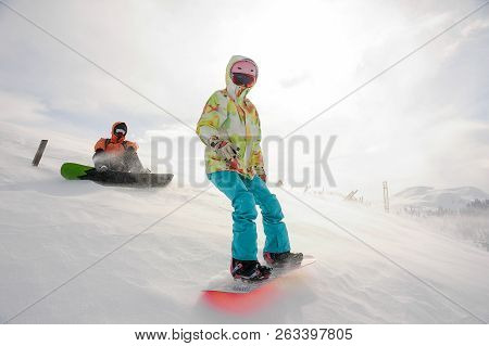 Two Snowboarders Running Down The Mountain Slope In The Popular Tourist Resort In Goderzi, Georgia