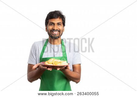 Cheerful Indian Man Employee At Supermarket Or Hypermarket Presenting Dish With Donuts With Happy Ex