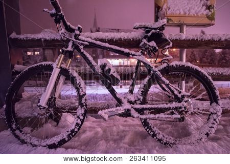 end of biking season.parked bicycle covered by snow from a heavy snowstorm.Winter cycling