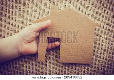 Hand Holding A Aper House On A Canvas Background