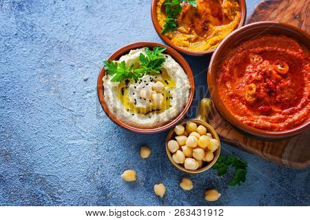  pumpkin hummus red pepper hummus and lentils hummus on wooden table