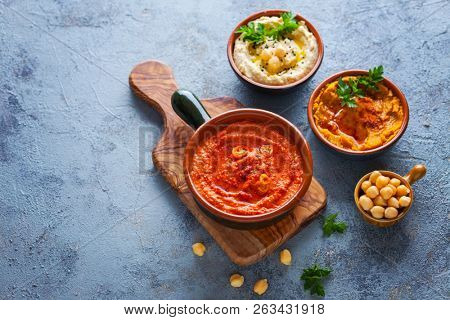  pumpkin hummus red pepper hummus and lentils hummus on wooden table