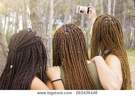 Three Young And Beautiful Girls, With Braided Hair, Taking Selfie