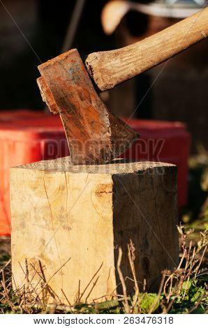 Old Rusty Vintage Axe Stuck In A Block Of Wood Used For Chopping Other Wood