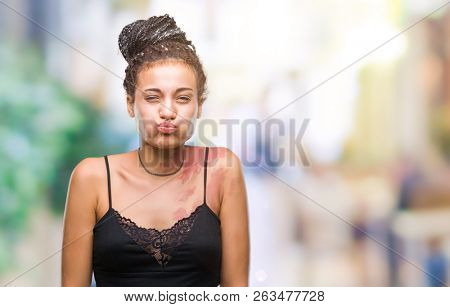 Young braided hair african american with pigmentation blemish birth mark over isolated background puffing cheeks with funny face. Mouth inflated with air, crazy expression.