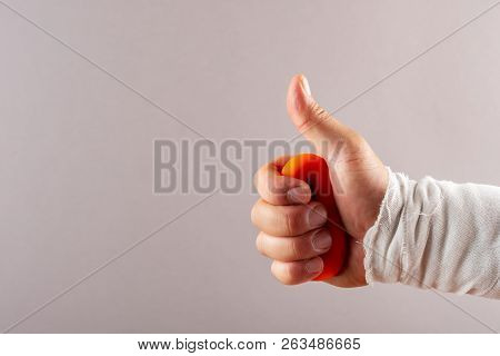Hurt Hand Doing Rehabilitation Exercises By Squeezing An O Ring Hand Trainer
