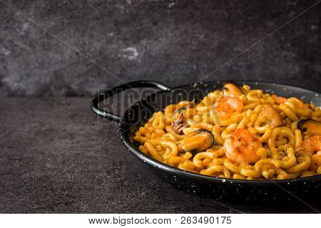 Traditional Spanish Fideua. Noodle Paella On Black Stone. Copyspace
