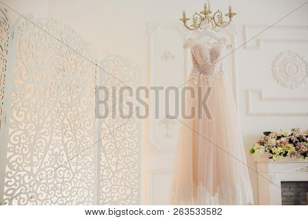 Wedding Dress Hanging On Luster At Hotel Room.