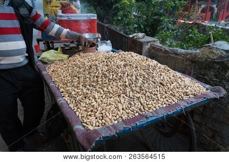 A Man Selling Roasted Peanuts In A Cart. Peanuts Fried In The Street. Indian Way Of Roasting Peanuts