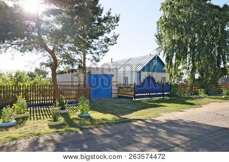 Beautiful Suburban House Outside View With Colorful Summer Gardens.