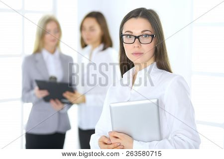 Attractive Business Woman Working With A Tablet Pc Against The Background Of Colleagues. Lawyer Or S
