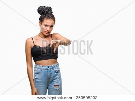 Young braided hair african american with pigmentation blemish birth mark over isolated background looking unhappy and angry showing rejection and negative with thumbs down gesture. Bad expression.
