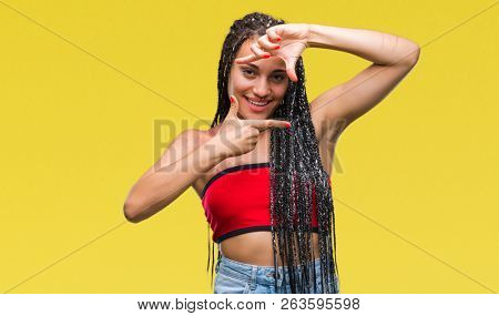 Young braided hair african american with pigmentation blemish birth mark over isolated background smiling making frame with hands and fingers with happy face. Creativity and photography concept.