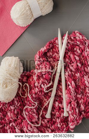 Knitting Yarns And Knitting Needles On Grey Background.