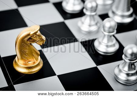 Gold Chess Pieces On A Black And White Chess Board.