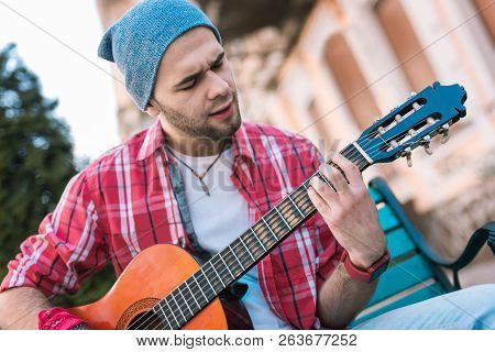 Pensive Street Musician Extemporizing On His Guitar