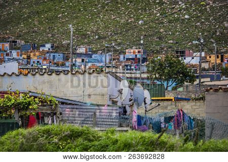 Wide Shot Of Shack Homes In Township Below Massive Mountain In Kleinmond, Western Cape, South Africa