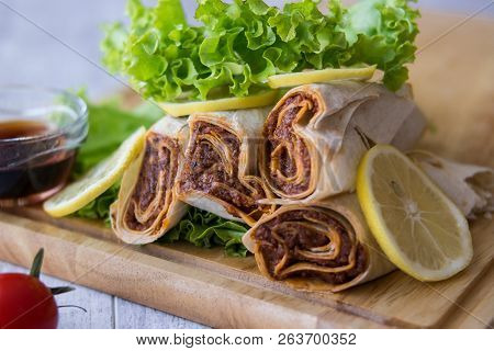 Cig Kofte / Kofta Shawarma On Wooden Plate Served With Greens And Lemons.