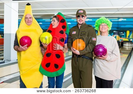 Happy family in fancy clothes holding bowling ball