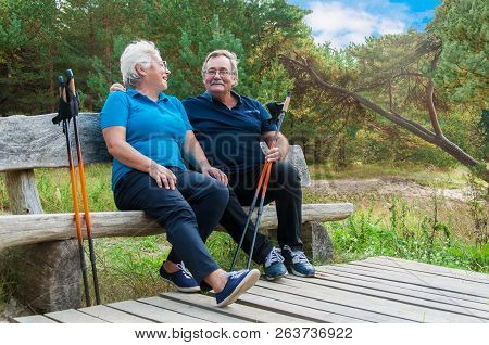 Сheerful Senior Couple Resting After Nordic Walking