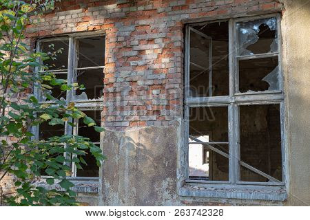 A Broken Window In An Old Abandoned Building. Broken Glass On The Window Site. Old Building.