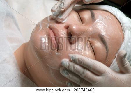 Close-up. East Girl On The Procedure Of Cleansing Of The Skin In The Beauty Salon. The Hands Of A Pr