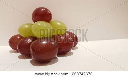 Mixed Grapes Stacked Into A Pyramid On White Background.